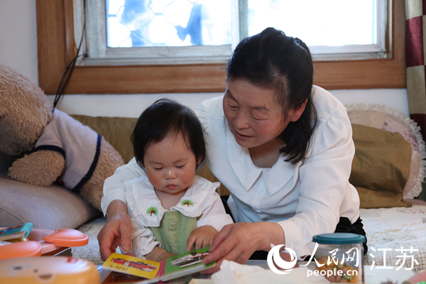 王繼蓮帶孫女看童書(shū)。人民網(wǎng) 冷金明攝