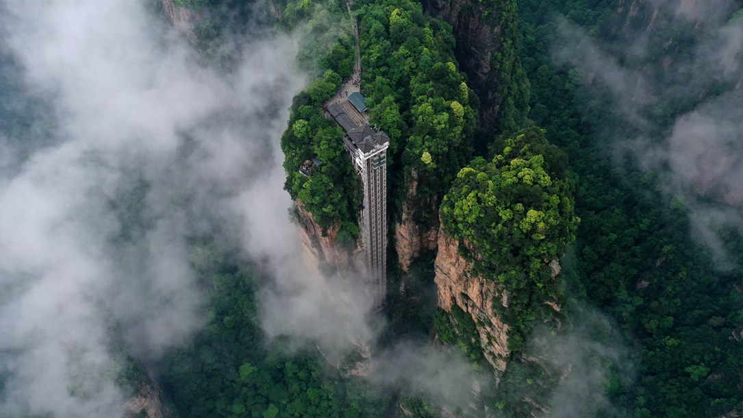 位于張家界武陵源景區(qū)的百龍?zhí)焯蓁偳对谠旗F繚繞的峰林間，雄偉壯觀。吳勇兵攝
