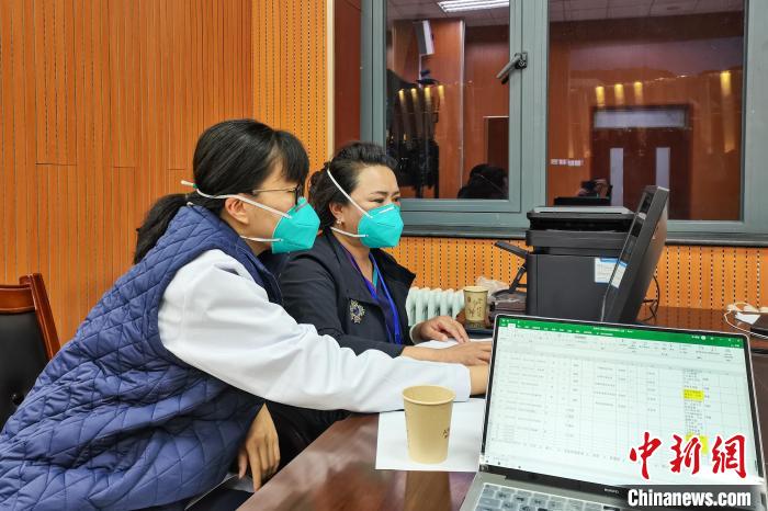 8月9日，楊蘇喬(左)在拉薩方艙醫(yī)院指揮部讀取艙內(nèi)患者胸部CT。　受訪者供圖