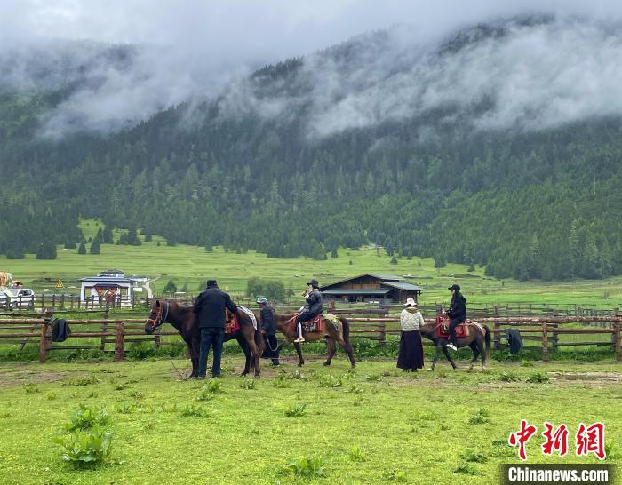 6月10日，游客在魯朗小鎮(zhèn)高山牧場景區(qū)體驗騎馬?！∪轿木?攝