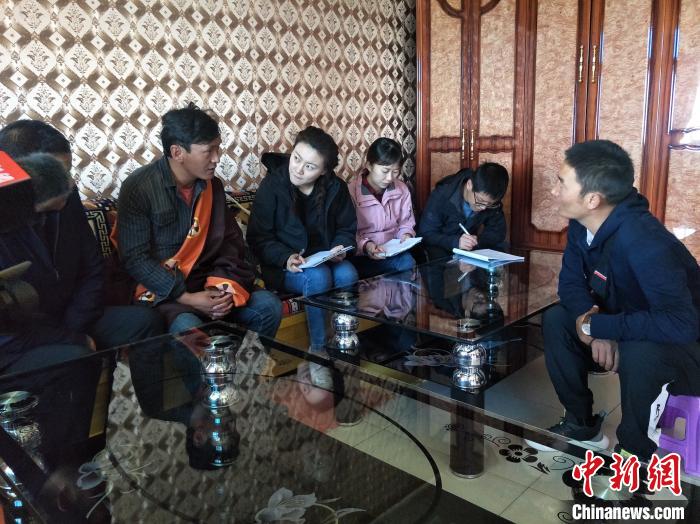 圖為調(diào)查組工作人員正在入戶調(diào)查?！∑钤鲚?攝
