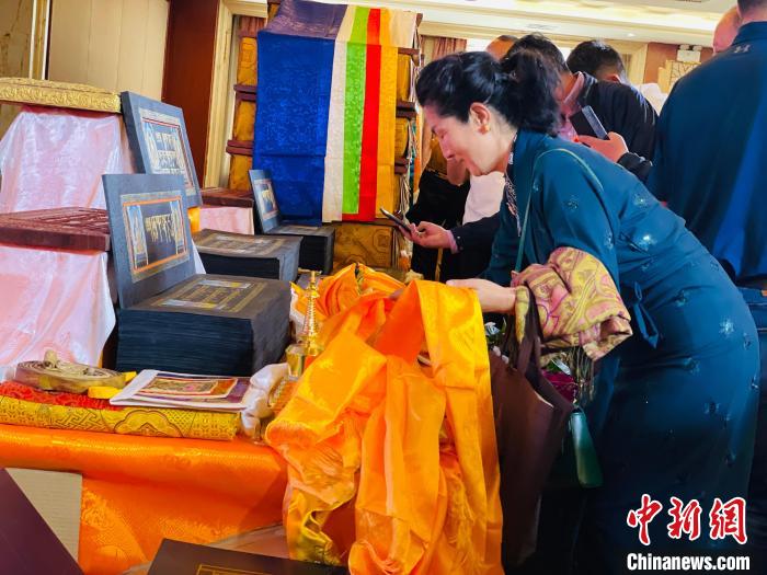 圖為現(xiàn)場藏族民眾向黃金書寫的大藏經(jīng)《甘珠爾》敬獻哈達?！O睿 攝