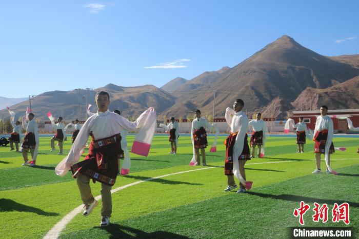 圖為青海師范大學(xué)附屬玉樹實驗學(xué)校學(xué)生在綠茵場跳起囊謙古舞—卓根瑪?！〕逃?攝