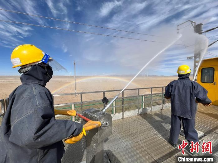 圖為水炮手操作高壓水槍對(duì)絕緣子進(jìn)行清洗。　高啟宏 攝