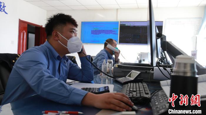圖為貨運(yùn)調(diào)度人員與外勤工作人員聯(lián)系掌握車輛裝載情況?！±钌?攝