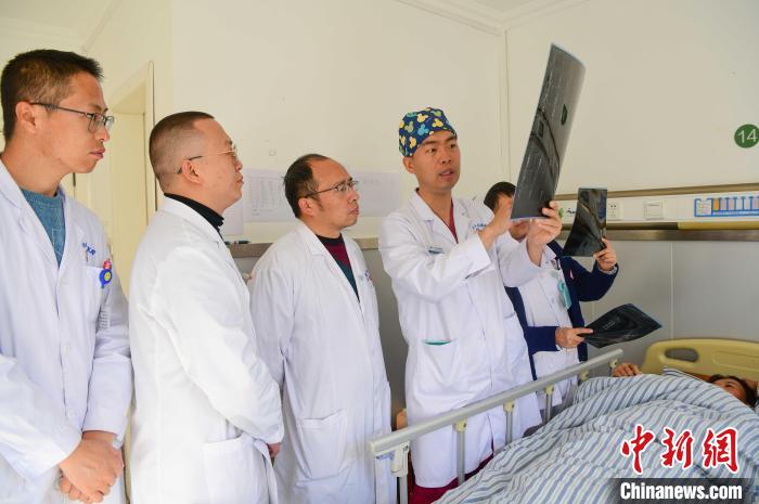 圖為何蔚副主任醫(yī)師(站右二)及團隊討論患者病情?！∝暩聛硭?攝