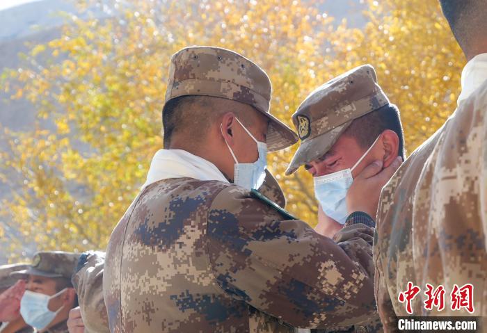 圖為什布奇邊防連退伍老兵與戰(zhàn)友相擁而泣，依依惜別?！⌒觳?攝