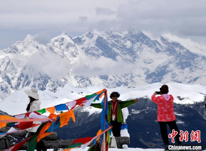 圖為5月14日，西藏林芝色季拉山觀景臺，游客與南迦巴瓦峰合影。　李林 攝